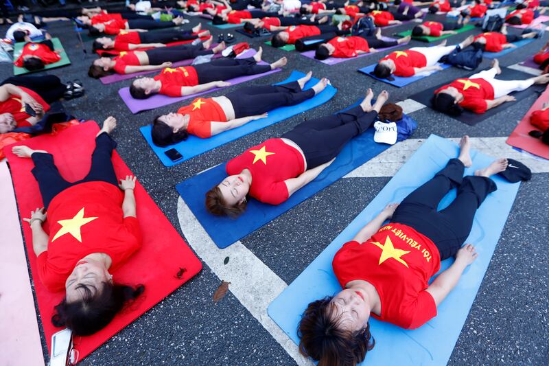 People take part in a yoga exercise ahead of the 9th International Day of Yoga by Hoan Kiem lake in Hanoi, Vietnam. EPA