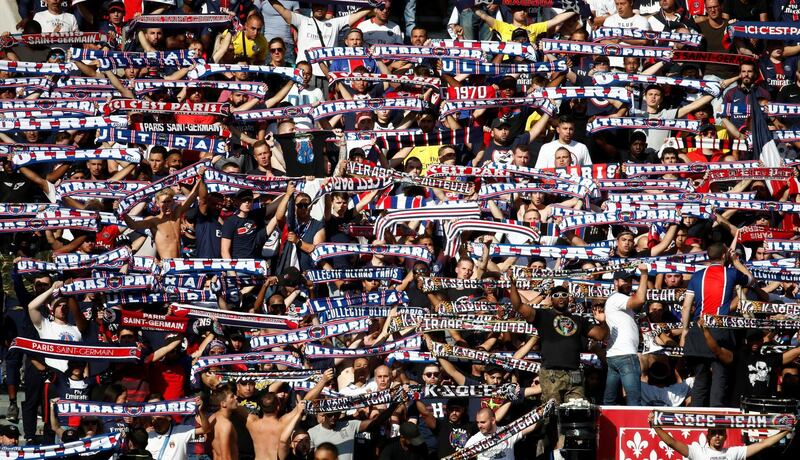 Paris St Germain fans hold up their scarves during the match. Reuters
