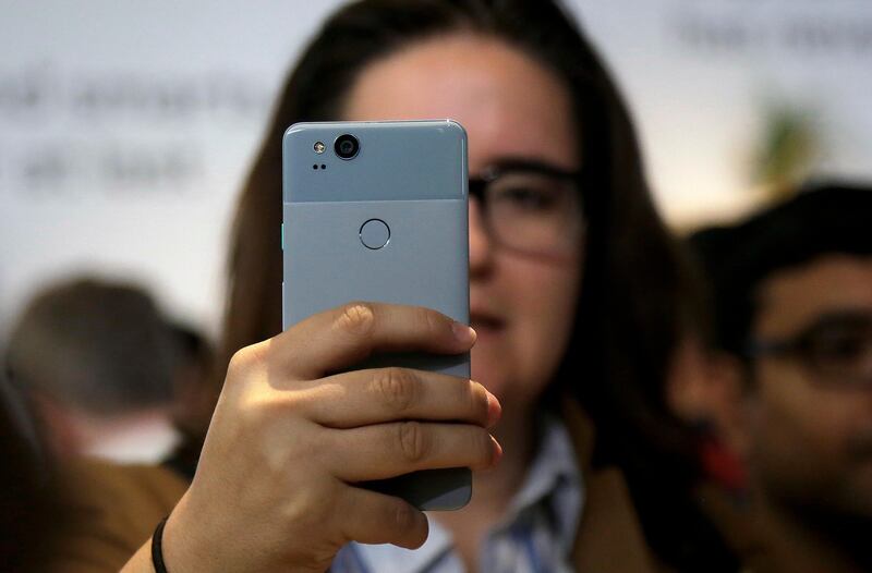 A woman looks at a Google Pixel 2 phone at a Google event at the SFJAZZ Center in San Francisco. Jeff Chiu / AP Photo