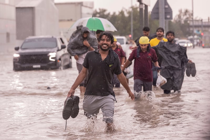One pedestrian is still smiling despite the flooding, in Al Quoz, Dubai. Antonie Robertson / The National