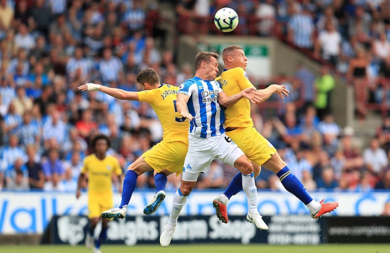 Huddersfield Town's Jonathan Hogg, centre, battles with Chelsea's Jorginho, left, and Ross Barkley. PA / AP