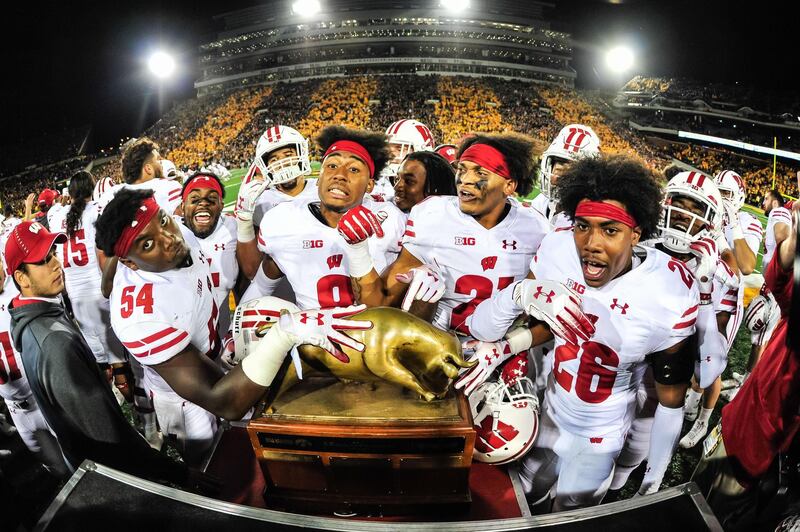 The Wisconsin Badgers surround the Heartland Trophy after defeating the Iowa Hawkeyes at Kinnick Stadium, Iowa. Jeffrey Becker/Reuters