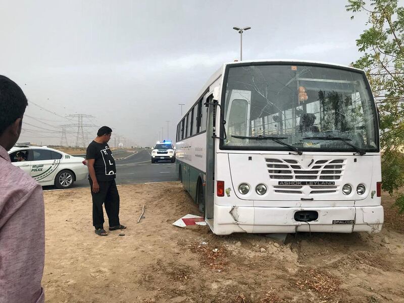 A driver surveys his beached coach. Dubai traffic police