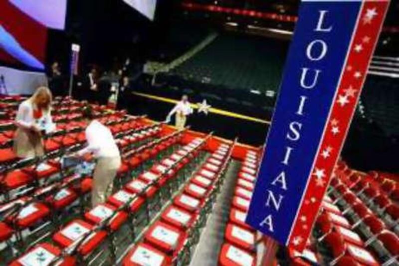 Workers place seating packets on the chairs of the Louisiana delegation yesterday.