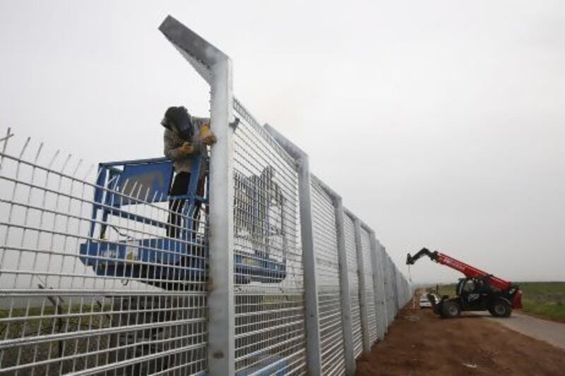 Workers reinforce the fence near Israel's border with Syria in the Golan Heights.