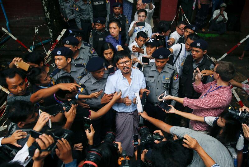 epa06874599 Detained Reuter's journalist Wa Lone (C) is escorted by police as he talks to the media after a trial at the court in Yangon, Myanmar, 09 July 2018. The Yangon court on 09 July 2018 charged both reporters with breaching the Official Secret Act.  EPA/LYNN BO BO