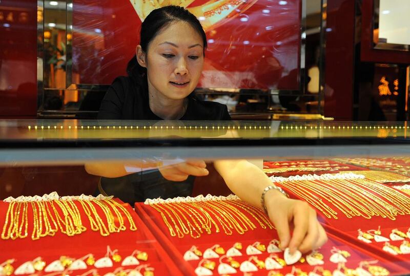 Gold trading volumes for the Shanghai Gold Exchange were up nearly 22 per cent in September. A woman arranges gold jewellery on display at a shop in east China’s Anhui province. AFP