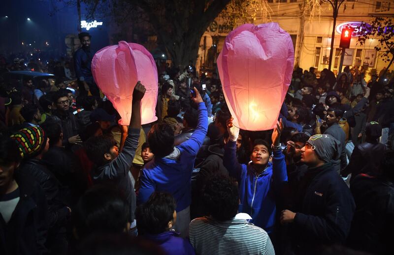 Pakistani people prepare to release New Year lanterns in Lahore. Arif Ali / AFP Photo