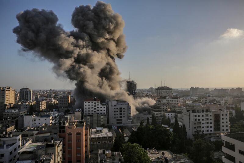 epaselect epa09195385 Smoke rise after an Israeli strike Al-Shorouq tower in Gaza City, 12 May 2021. In response to days of violent confrontations between Israeli security forces and Palestinians in Jerusalem, various Palestinian militants factions in Gaza launched rocket attacks since 10 May that killed at least six Israelis to date. Gaza Strip's health ministry said that at least 65 Palestinians, including 13 children, were killed in the recent retaliatory Israeli airstrikes. Hamas confirmed the death of Bassem Issa, its Gaza City commander, during an airstrike.  EPA/MOHAMMED SABER