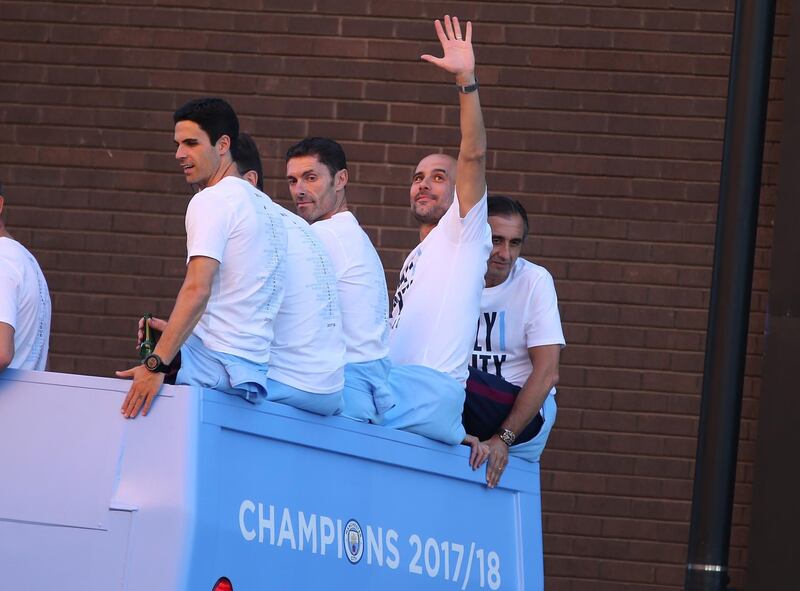 Manchester City's manager Pep Guardiola, second right, waves during a bus parade to celebrate their English Premier League title win. Nigel Roddis / EPA