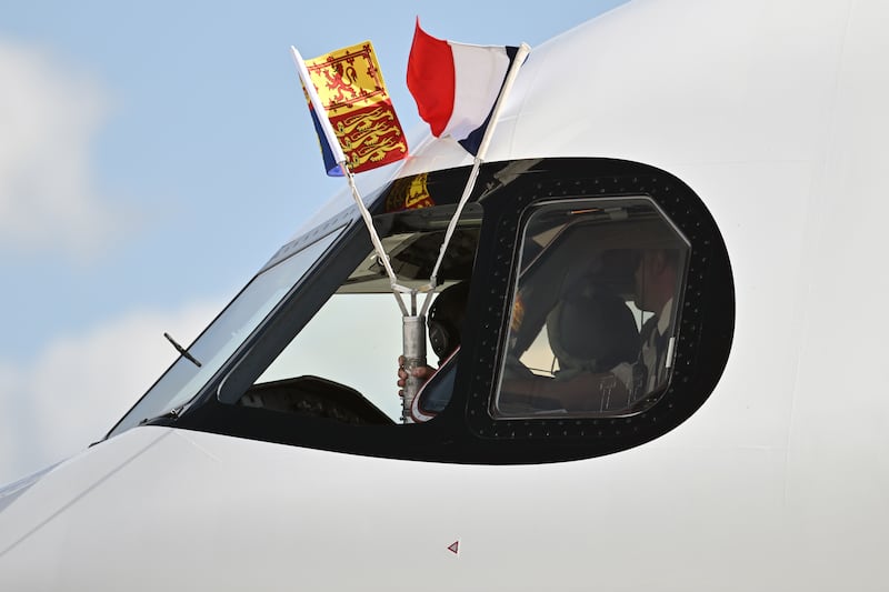 The Royal Standard and the French flag are flown from the window of the cockpit as the plane carrying King Charles arrives in Paris. PA