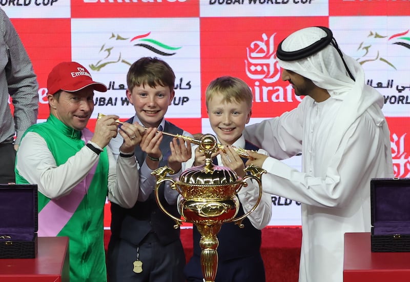 Sheikh Hamdan bin Mohammed, Crown Prince of Dubai and Chairman of Dubai Executive Council, hands the trophy to jockey Tadhg O'Shea, left, after he won the Dubai World Cup on Laurel River. EPA