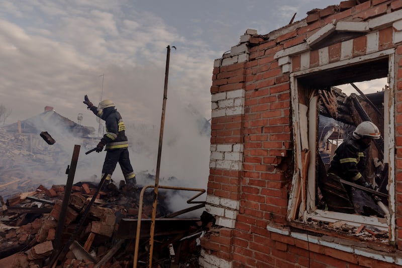 Firefighters work amid the debris of residential houses that were destroyed by Russian shelling in a settlement outside Kharkiv. Reuters