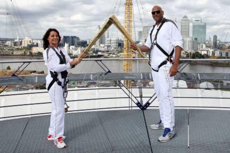 The photo provided by LOCOG shows torchbearers Nadia Comaneci, left, and John Amaechi as they handing over the light of the Olympic Torch on the viewing platform of the North Greenwich Arena, London, Saturday, July 21, 2012. (AP Photo/LOCOG, Gareth Fuller) *** Local Caption ***  London Olympics Torch.JPEG-0ad45.jpg