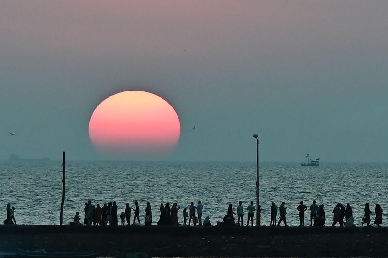 People at the seafront as the sunsets near Haji Ali mosque in Mumbai. AFP