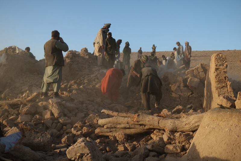 Afghan residents clear debris from a damaged house after an earthquake in the Sarbuland village of Zendeh Jan district in Herat province. AFP