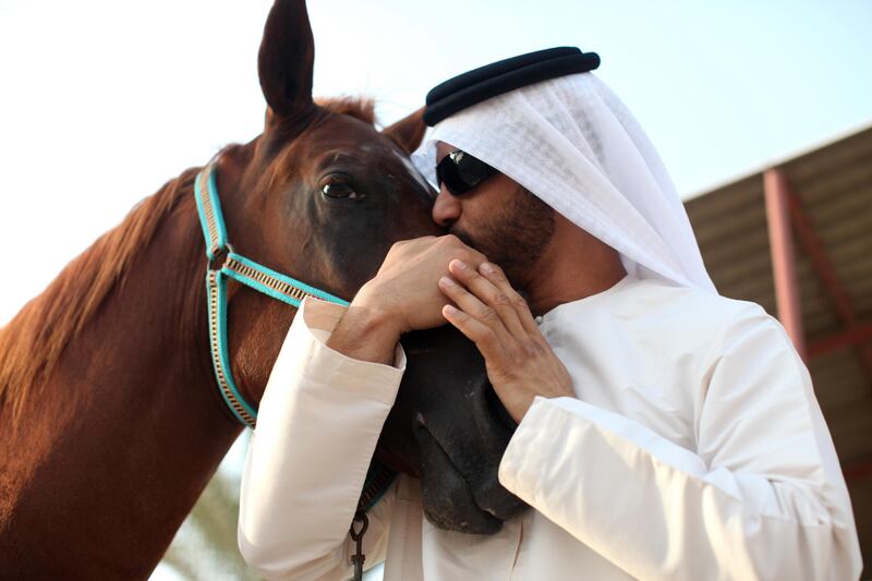 August 15 2011- Shahama, UAE - Mohammad Saif nuzzles up to "Ajeeb" (slang word in Arabic for "awesome"), his favourite racing horse at the Shahama Equestrian Club. A resident of Al-Rahba, he keeps three horses at the stables to train them for races and hopes to one day have them compete at Meydan. When the weather is pleasant he says he comes to the centre with his friends to sit on the grass, have a coffee and socialise. (Razan Alzayani / The National) 