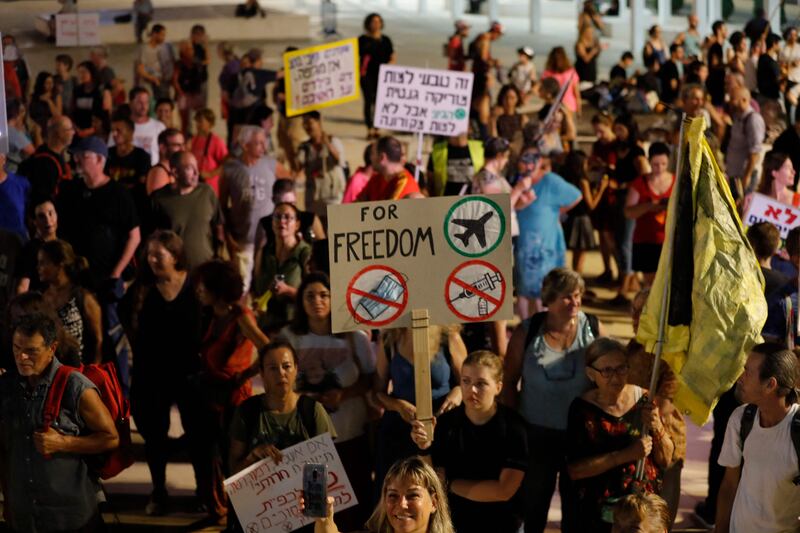 Israelis hold placards at a rally in Tel Aviv on July 31, 2021 denouncing the government’s renewed restrictions to combat Covid-19.