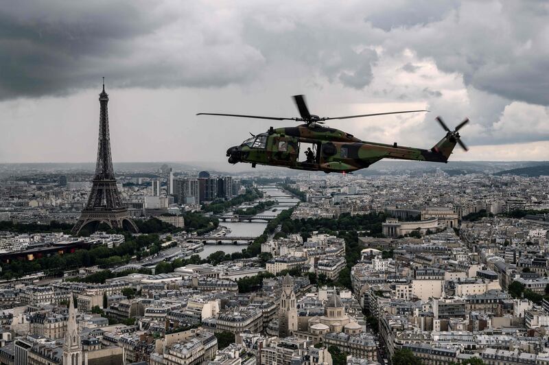 An NH90 "CAIMAN" helicopter flies over the Eiffel Tower and the Seine river during a practice session prior to July 14's Bastille Day Parade in Paris.