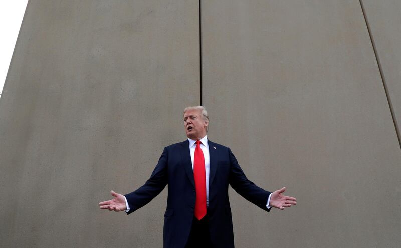 In this March 13, 2018 photo, President Donald Trump speaks during a tour as he reviews border wall prototypes in San Diego. Trump hails the start of his long-sought southern border wall, proudly tweeting photos of the â€œWALL!â€ Actually, no new work got underway. The photos show the continuation of an old project to replace two miles of existing barrier. (AP Photo/Evan Vucci)