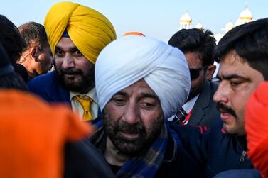 Security personnel escort Indian Bollywood actor Sunny Deol, centre, and Indian politician and former cricketer Navjot Singh Sidhu, left,  as they visit the Shrine of Baba Guru Nanak Dev at Gurdwara Darbar Sahib in Kartarpur, near the Indian border, on November 9, 2019. AFP