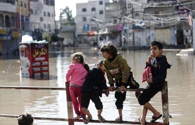 Palestinian children play on a flooded street following heavy rains in Jabalia refugee camp in northern Gaza strip on January 5, 2020. / AFP / MAHMUD HAMS
