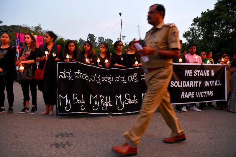 A policeman walks past as people hold a candlelight vigil in support of sexual assault victims and against the alleged rape and murder of a 27-year-old veterinary doctor in Hyderabad, in Bangalore. AFP