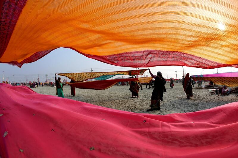 Hindu devotees dry their clothes after taking spiritual-cleansing dips in the Sangam during the Kumbh Festival, in Allahabad, India. AP Photo