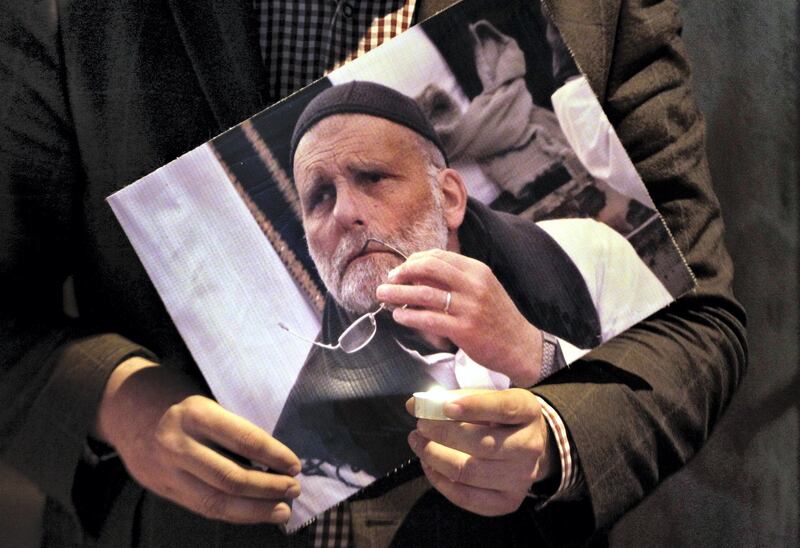 FILE - In this file photo taken Wednesday, Jan. 29, 2014, a Lebanese man holds a picture of Italian Jesuit priest, Father Paolo Dall'Oglio, who was kidnapped in Syria, during a vigil calling for his release, as they gather at the St. Joseph church in Beirut, Lebanon. The Italian Jesuit priest went missing in July 2013 after traveling to meet Islamic militants in the Syrian city of Raqqa. He has not been seen since. (AP Photo/Bilal Hussein, File)