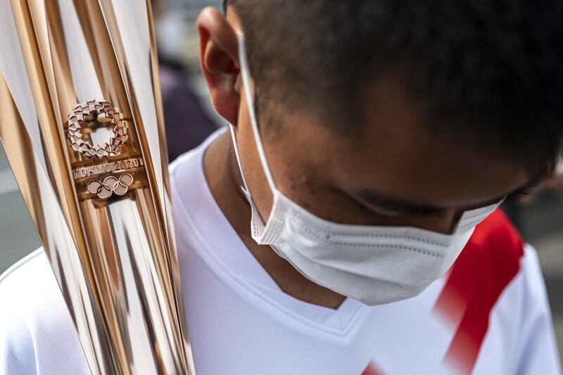 Mahiro Abe, a member of Japan's self-defence forces, waits to receive the Olympic torch during the first day of the relay in the town of Naraha, Fukushima. AFP