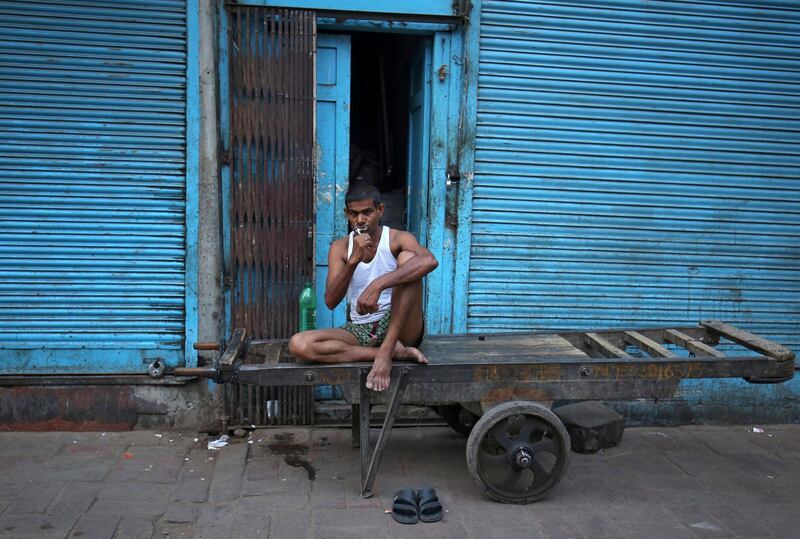 A labourer brushes his teeth as he sits on a handcart in a market area in the old quarters of Delhi, India. Amit Dave / Reuters