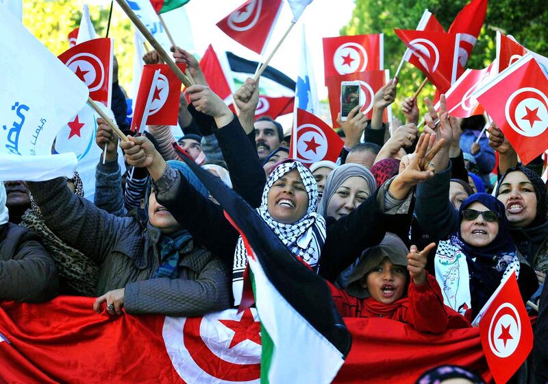 Tunisian people march with national flags during a rally to mark seven years since revolution in Tunis, Tunisia, Sunday, Jan. 14, 2018. Tunisian authorities announced plans to boost aid to the needy in a bid to placate protesters whose demonstrations over price hikes degenerated into days of unrest across the North African nation, which is marking seven years on Sunday since its long-time autocratic ruler was driven into exile. (AP Photo/Hassene Dridi)