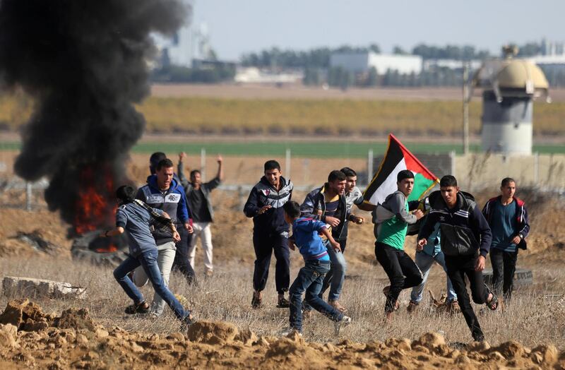 Palestinian protesters run during clashes near the border with Israel in the southern Gaza Strip. Ibraheem Abu Mustafa / Reuters