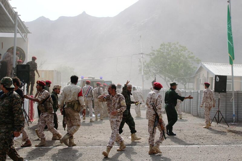 Soldiers rush to help the injured following a missile attack on the military parade. Reuters