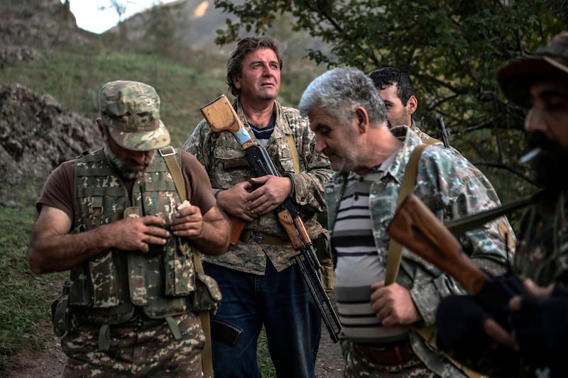 Volunteer fighters stand in a village south-east of Stepanakert during the ongoing fighting between Armenian and Azerbaijani forces. AFP