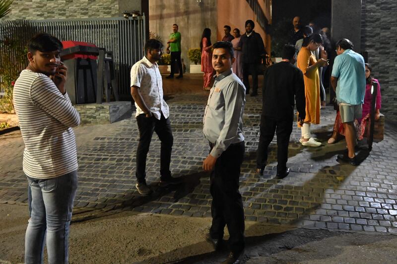 Visitors to the north-west Indian city of Amritsar gather outside their hotel after the earthquake. AFP
