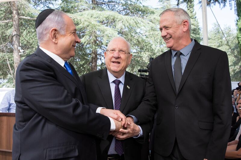 epa08329017 (FILE) -  Israeli Prime Minister Benjamin Netanyahu (L), Israeli President Reuven Rivlin (C) and Benny Gantz, former Israeli Army Chief of Staff and chairman of the Blue and White Israeli centrist political alliance (R) join hands as they attend a memorial service for late Israeli president Shimon Peres at Mount Herzl, Israel's national cemetery, in Jerusalem, 19 September 2019. Media reports that Netanyahu has cracked down on advance talks about going to unity government following the state crisis  dealing with the spread of the SARS-CoV-2 coronavirus.  EPA/ABIR SULTAN