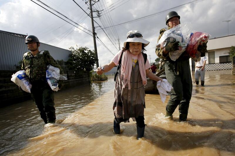 Soldiers from the Japanese self-defence force escort an elderly woman after flooding forced her from her home in Joso, Ibaraki prefecture. Issei Kato / Reuters
