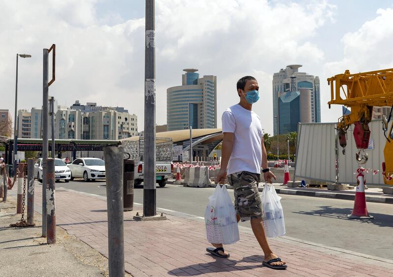 Dubai, United Arab Emirates - Reporter: N/A: A man carries his shopping while wearing a face mask in Al Rigger in response to the corona virus. Wednesday, March 25th, 2020. Dubai. Chris Whiteoak / The National
