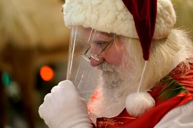 Santa Claus adjusts his protective face shield between visits from children and their families at a shopping centre in Miami. AP