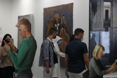 Visitors look at a cut-out artwork by American artist Michelangelo Pistoletto during Art Dubai 2020 at Dubai International Financial Centre. EPA