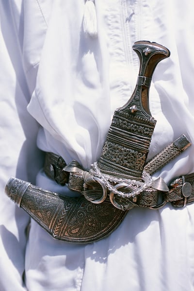 Oman, Jabal al Akhdar, Jebel Shams. Omani men wear the traditional long white robes and ceremonial khanjar or curved dagger up on Al Jabal al Akhdar. Getty Images