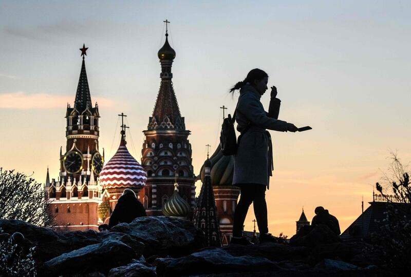 A tourist takes a selfie in front of the Kremlin and St Basil Cathedral at sunset in Moscow, Russia. AFP