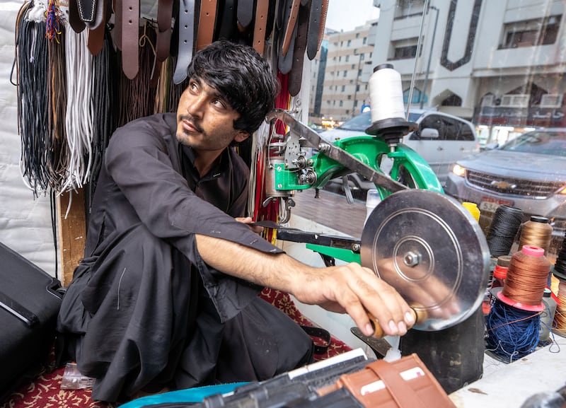 Issa Sherani, 26, from Pakistan, works for his brother as a shoe and leather repair technician at Stars Gallery Shop