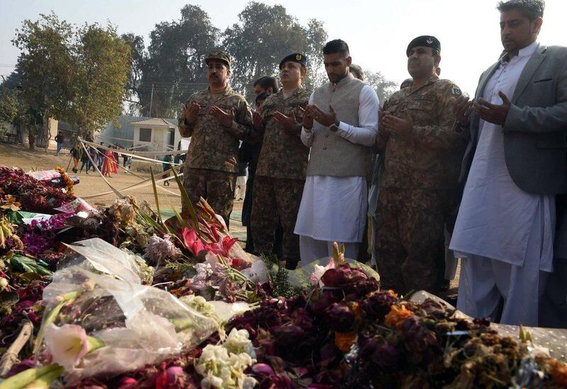 Amir Khan prays at the memorial at the army-run school in Peshawar, Pakistan on Monday where 148 people were murdered by the Taliban on December 16. A Majeed / AFP
