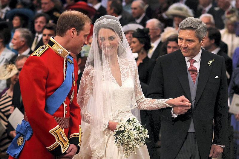 LONDON, ENGLAND - APRIL 29: Prince William speaks to his bride, Catherine Middleton as she holds the hand of her father Michael Middleton at Westminster Abbey on April 29, 2011 in London, England.  The marriage of Prince William, the second in line to the British throne, to Catherine Middleton is being held in London today. The marriage of the second in line to the British throne is to be led by the Archbishop of Canterbury and will be attended by 1900 guests, including foreign Royal family members and heads of state. Thousands of well-wishers from around the world have also flocked to London to witness the spectacle and pageantry of the Royal Wedding.  (Photo by Dominic Lipinski - WPA Pool/Getty Images)