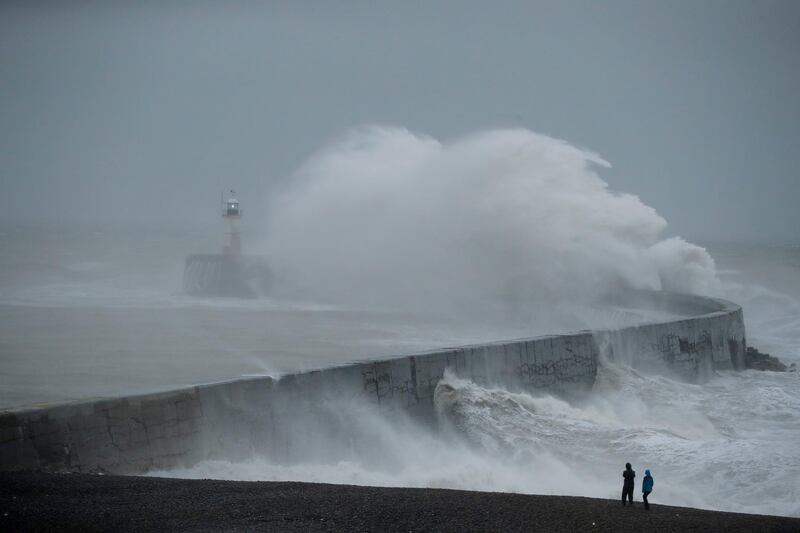 Waves crash over the harbour wall by a lighthouse as Storm Ciara hits Newhaven, on the south coast of England. AP Photo