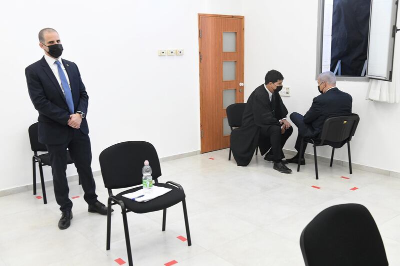 Israeli Prime Minister Benjamin Netanyahu speaks to a member of his legal team before the start of a hearing in his corruption trial at Jerusalem's District Court.  Reuters