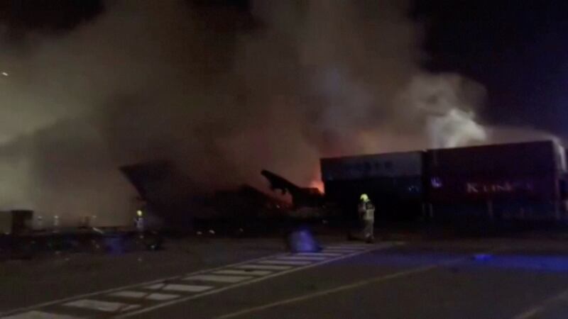 Smoke rises from the container ship.