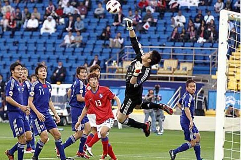 Japan's goalkeeper Eiji Kawashima jumps to effect a save.